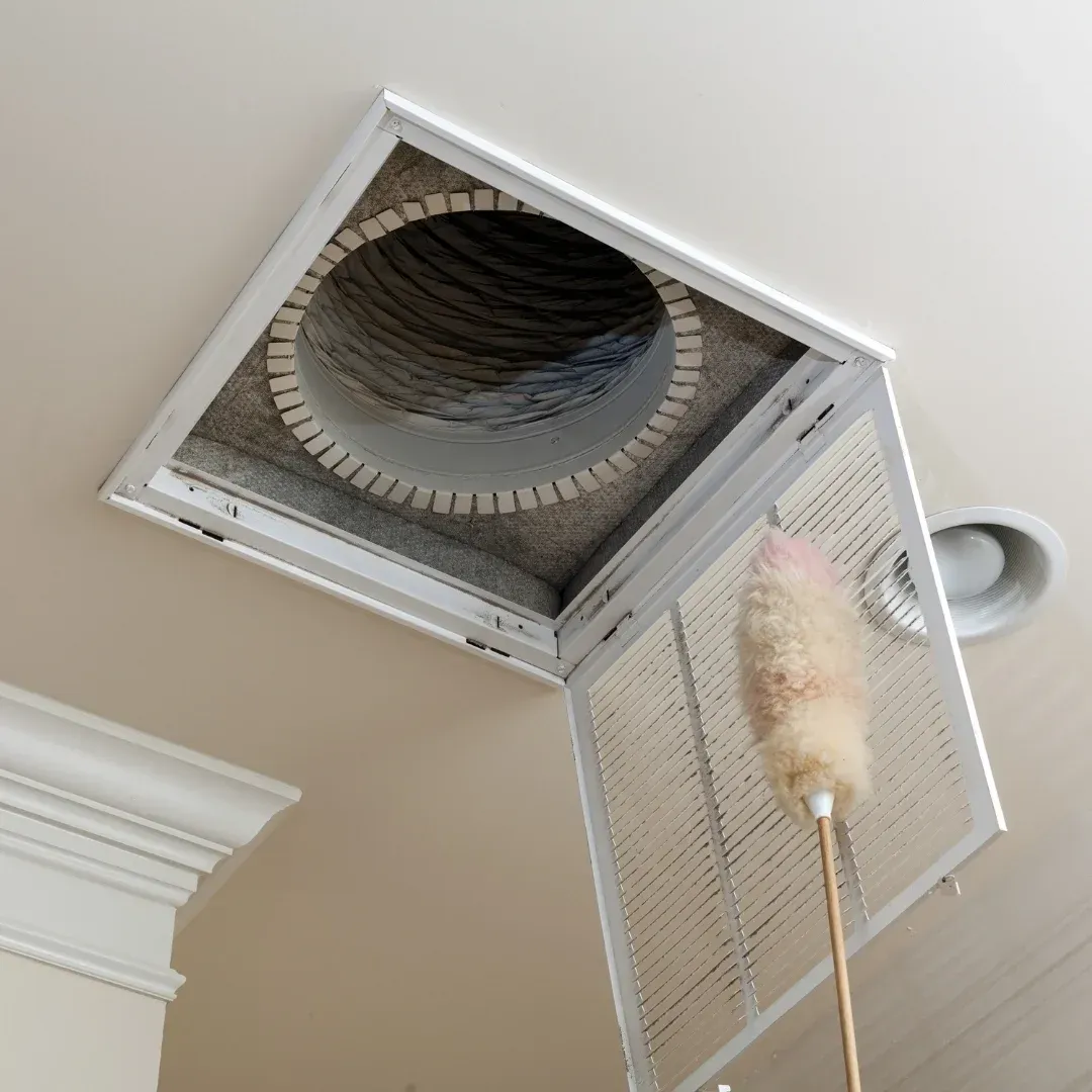 Cleaning a ceiling vent hatch on a white ceiling